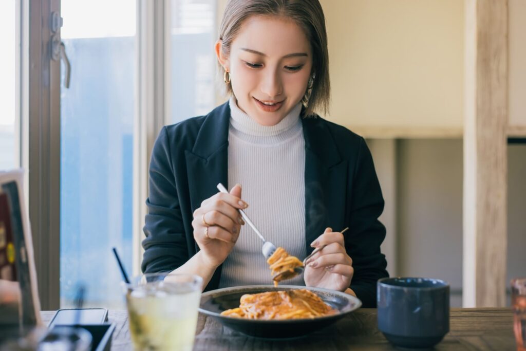 パスタを食べる30代女性