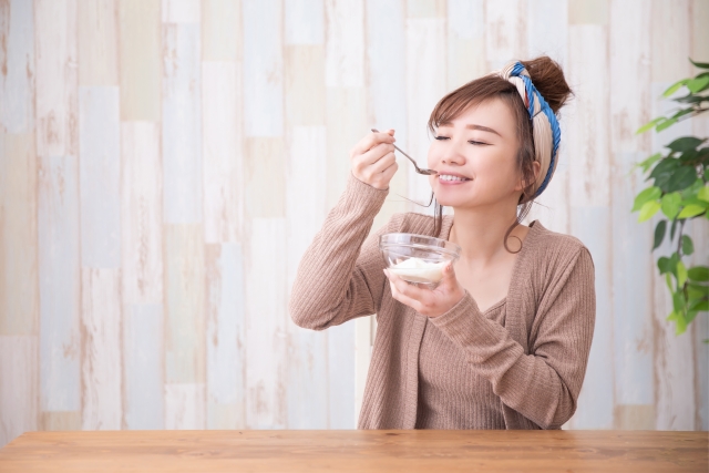 ダイエット中に美味しそうにヨーグルトを食べる女性