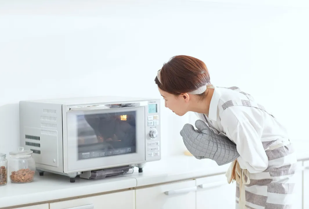 レンジの中をのぞく女性