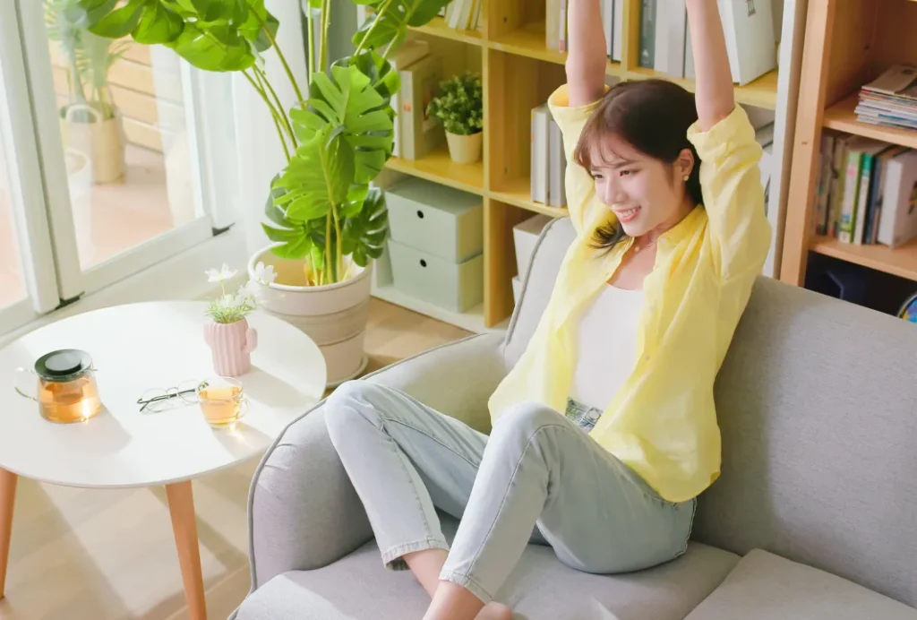 テレビを見ながらストレッチをする女性