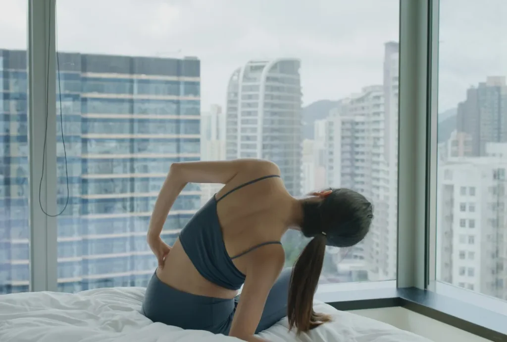ベッドの上でストレッチをする女性