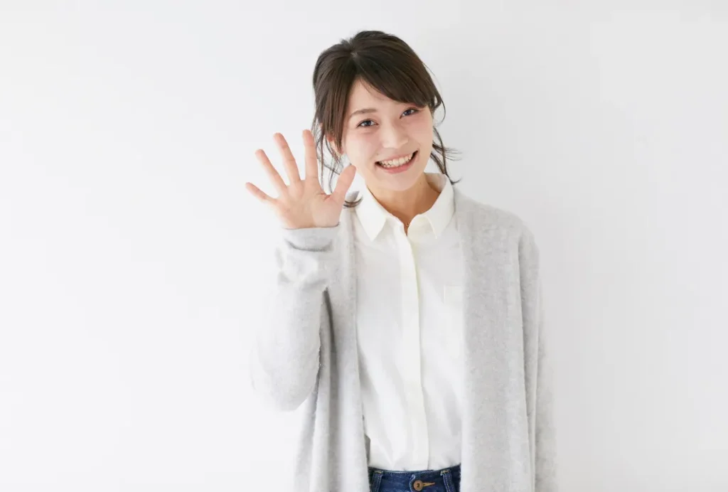 手で「5」を表す女性
