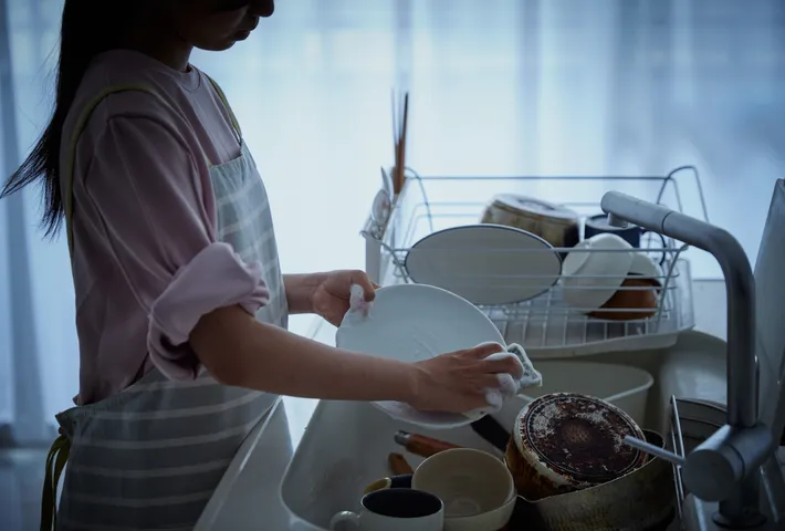 お皿洗いをする女性